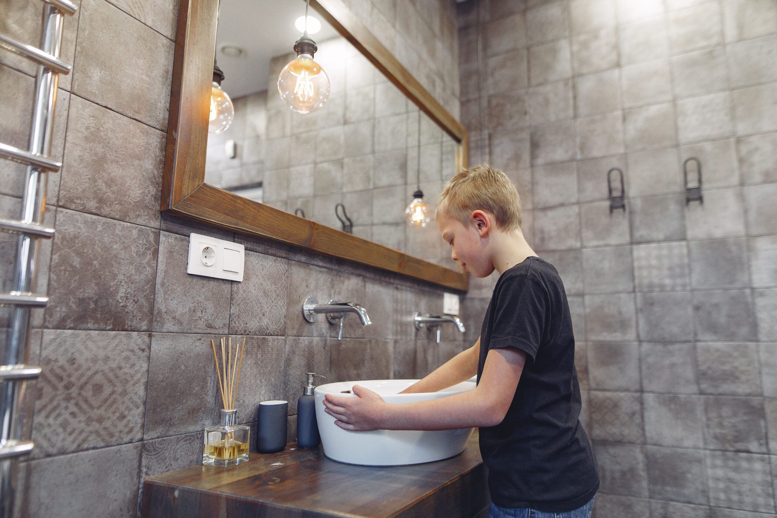 bambino al lavabo con acqua calda