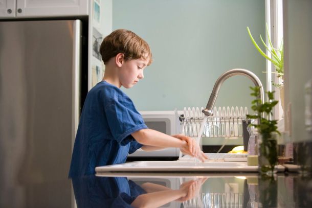 bambino si lava le mani con acqua calda
