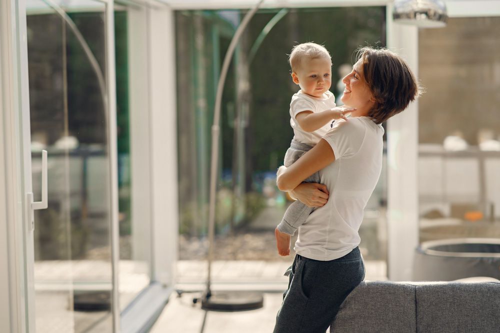 mamma felice con il suo bambino in casa piena di luce