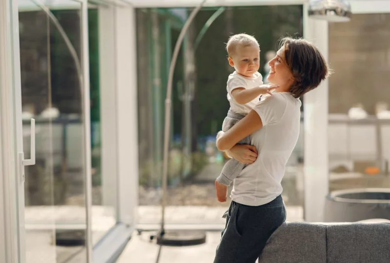 mamma felice con il suo bambino in casa piena di luce