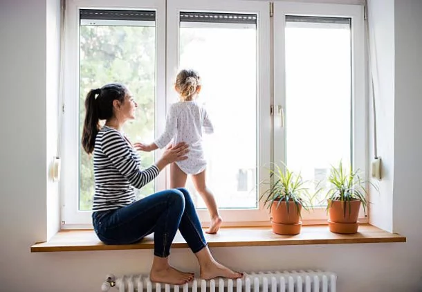 mamma figlia gioca alla finestra sopra termosifone