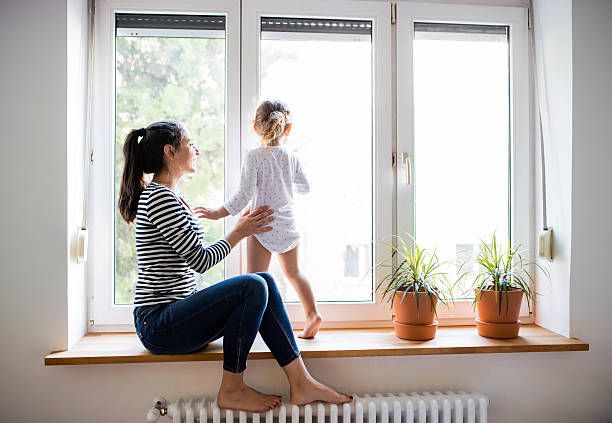 mamma figlia gioca alla finestra sopra termosifone