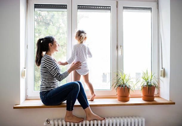mamma figlia gioca alla finestra sopra termosifone