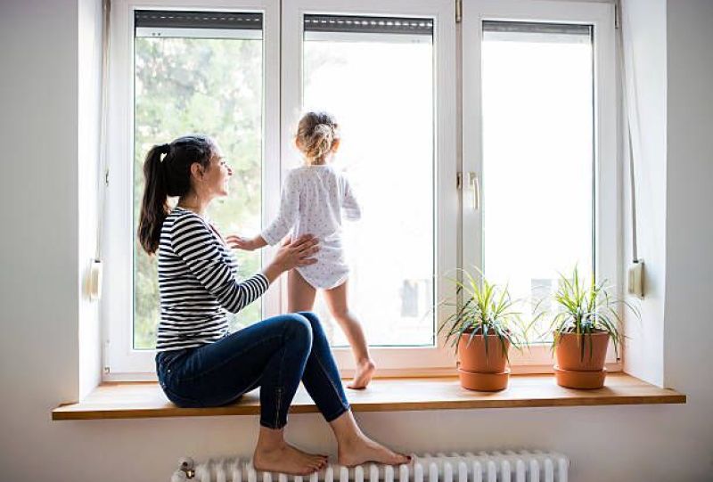 mamma figlia gioca alla finestra sopra termosifone